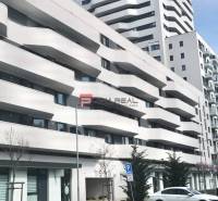 Das Gebäude mit Balkonen in der Údernícka-Straße in Bratislava V, Garagen im Vordergrund.