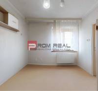 Ein Zimmer mit Regal und Schrank in einem Einfamilienhaus, sanfte Farbtöne, ein Raum mit Fenster.