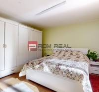 Schlafzimmer mit großem Schrank, Bett mit Blumenüberwurf in einem Einfamilienhaus.