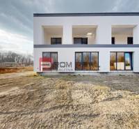 Ein Einfamilienhaus in Dunajská Streda mit weißer Fassade und großen Fenstern.
