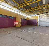 Geräumige Lagerhallen mit bunten Wänden, gelber Stahlkonstruktion und einem großen Garagentor.