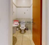 Toilette in Büroräumen mit Grundausstattung und Wandfliesen.