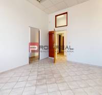 Büro mit weißen Wänden, Keramikboden und Holztüren.