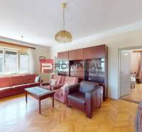 Wohnzimmer in einem Einfamilienhaus mit Sofa, Sessel und Schrankwand.