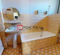 Badezimmer in einem Einfamilienhaus mit Dusche, Waschbecken, Spiegel und italienischen Fliesen.