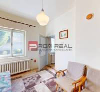 Zimmer in einem Einfamilienhaus mit Sofa, Fenster und Teppichaccessoire.