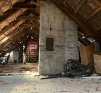 Der Dachboden mit Holzkonstruktion unter dem Dach in einem Einfamilienhaus, voll mit Gerümpel.