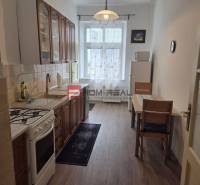 Küche in einer 2-Zimmer-Wohnung mit Gasherd, Esstisch und Schränken.