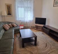 Wohnzimmer mit Ecksofa, Fernseher und Couchtisch in einer Zweizimmerwohnung.
