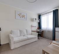Zimmer in einer 3-Zimmer-Wohnung mit Sofa, Schreibtisch und Fernseher.
