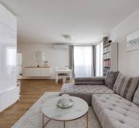 Wohnzimmer in einer 3-Zimmer-Wohnung mit stilvollem Sofa und minimalistischem Möbeln.