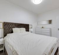 Schlafzimmer mit großem Bett, Nachttisch und Kommode in einer 3-Zimmer-Wohnung.