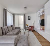Helles Wohnzimmer mit großem grauem Sofa und TV-Wand in einer 3-Zimmer-Wohnung.