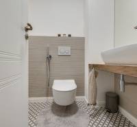 Badezimmer mit hängendem WC und Waschbecken in einer 3-Zimmer-Wohnung mit geometrischen Fliesen.