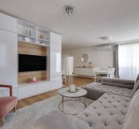 Wohnzimmer in einer 3-Zimmer-Wohnung mit bequemer Couch, TV-Wand und Esstisch.