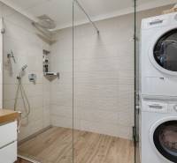 Badezimmer mit Dusche und Waschmaschine in einer 3-Zimmer-Wohnung.