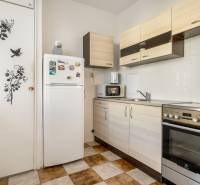 Küche in einer Einzimmerwohnung mit Küchenzeile, Herd und Kühlschrank.