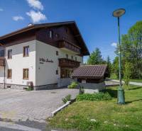 Ferienwohnung in der Hohen Tatra mit Parkplatz, Rasenfläche und sonnigem Wetter.