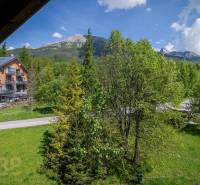 Blick aus einer Ferienwohnung in der Hohen Tatra, mit Bergen und grünen Bäumen.