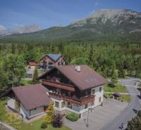 Ferienwohnungen in der Hohen Tatra, umgeben von dichtem Wald und majestätischen Bergen.