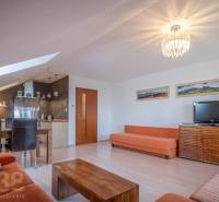 Wohnzimmer der Ferienwohnung mit Sofas, Esstisch und Fernseher.