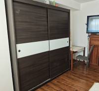 Ein Schrank mit Schiebetüren und ein Schreibtisch in einer 2-Zimmer-Wohnung.