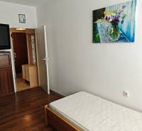 Ein einfaches Zimmer mit einem Bett und einem Bild in einer Zweizimmerwohnung.