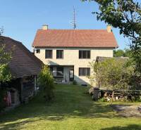 Ein Einfamilienhaus in Koválov mit Garten, Bäumen und einem geräumigen grünen Grundstück.