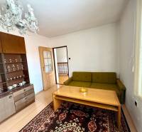 Wohnzimmer in einem Einfamilienhaus mit Sofa, Schrank, Kronleuchter und Teppich.
