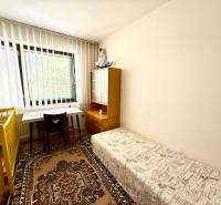 Kinderzimmer in einem Einfamilienhaus mit Tisch, Bett und Teppich.