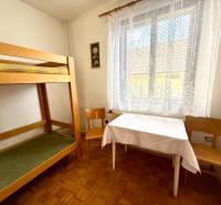 Ein Zimmer in einem Einfamilienhaus mit einem Etagenbett, einem Tisch und Stühlen.