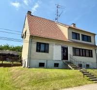 Ein Einfamilienhaus in Koválov mit einem rot-weißen Dach und gepflegtem Rasen.