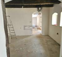 Unvollendetes Interieur in einem Einfamilienhaus mit freiliegenden Holzbalken und einer Leiter.