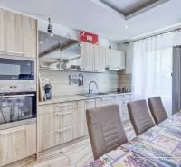 Küche in einer 2-Zimmer-Wohnung mit Holzschränken und eingebauten Geräten.