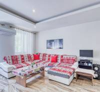 Wohnzimmer mit rotem Sofa und Tisch, 2-Zimmer-Wohnung, Klimaanlage.