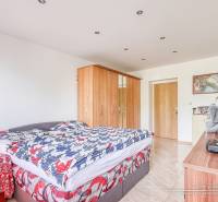 Schlafzimmer in einer 2-Zimmer-Wohnung mit Bett, Schrank und Dekorationen auf der Kommode.