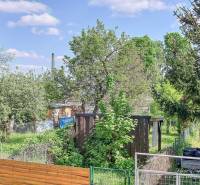 Ein Garten mit einem Holzunterstand, umgeben von Grün, in der Staničná-Straße in Trnava.