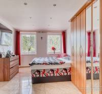 Schlafzimmer mit großem Schrank und Fernseher in einer 2-Zimmer-Wohnung.