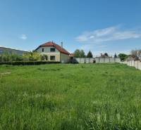 Grundstücke - Wohnen in Cabaj-Čápor mit Rasenfläche und Haus im Hintergrund.