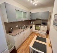 Küche in einer 2-Zimmer-Wohnung mit Holzboden und modernen Geräten.