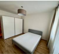 Schlafzimmer in einer 2-Zimmer-Wohnung mit Doppelbett, Einbauschrank und Holzboden.