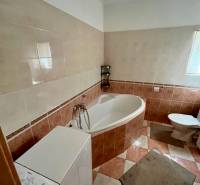 Badezimmer in einer 2-Zimmer-Wohnung mit Badewanne, Waschmaschine und Toilette.