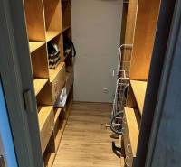 Kleiderschrank in einer 2-Zimmer-Wohnung, Holzregale, praktische Aufbewahrungsmöglichkeiten.