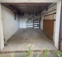 Leere Garage in Zvolen mit Regalen und Werkzeugen an der Wand.