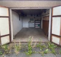 Eine offene Garage mit altem Interieur und Pflanzen vor der Garage in Zvolen.