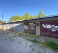 Garagen in Zvolen mit Graffiti auf den Toren, umgeben von Grünflächen und Betonflächen.