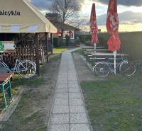 Gehweg neben Gastronomiebereichen mit Fahrrädern und Sonnenschirmen, Devínska Nová Ves, Devínske jazero.