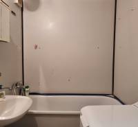 Badezimmer in einer 2-Zimmer-Wohnung mit Badewanne, Waschbecken und Waschmaschine.