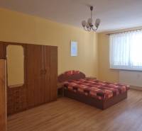 Schlafzimmer in einer 2-Zimmer-Wohnung mit Bett, Kleiderschrank und gelben Wänden.