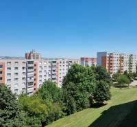 Wohnsiedlung mit Plattenbauten in der Petzwalova-Straße in Nitra, umgeben von Grünflächen und blauem Himmel.